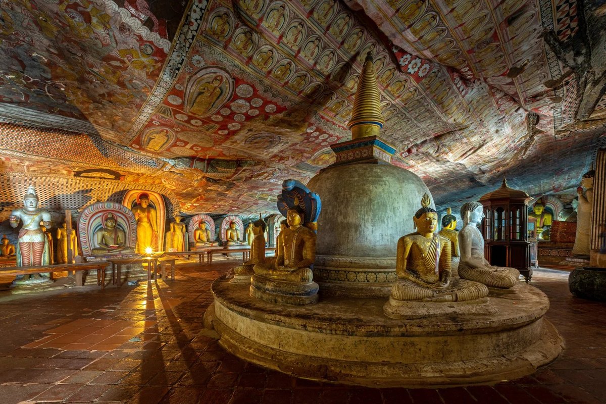 Dambulla Golden Cave Temple interior with reclining Buddha statues and ancient murals